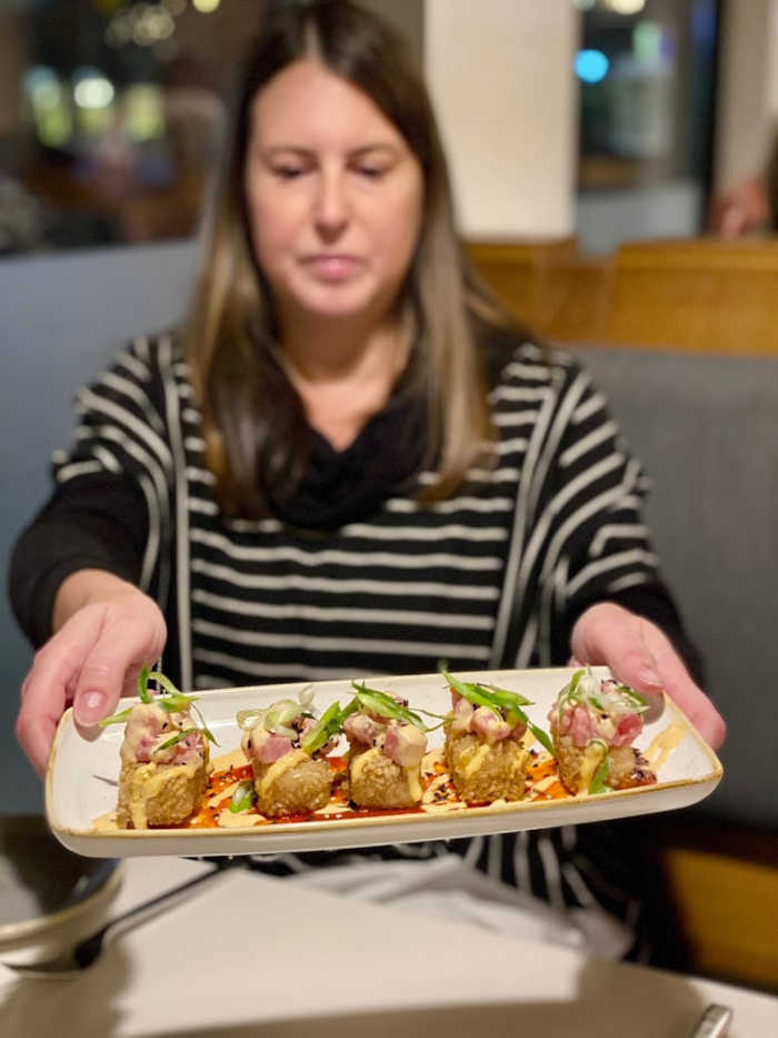 Tamara passes the tuna on rice at Everly restaurant in Madison