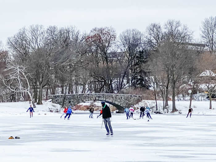 kids playing ice hockey on a lake
