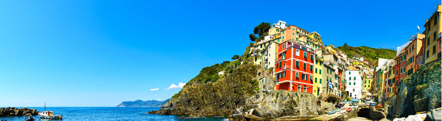 Riomaggiore village panoramic view on cliff rocks, boats and sea., Seascape in Five lands, Cinque Terre National Park, Liguria Italy Europe.