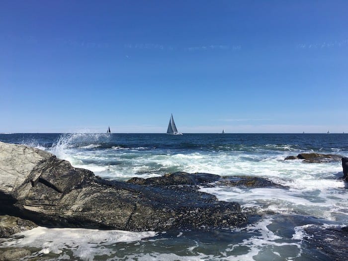 waves crashing on rocks and sailboat at Beavertail state park