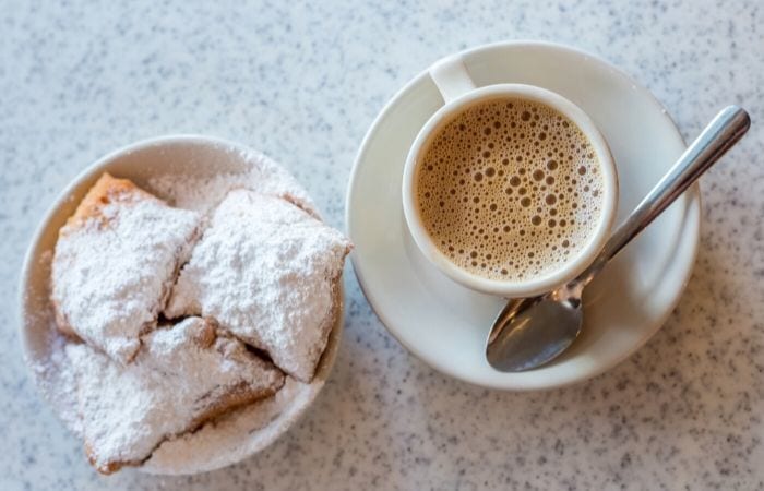 beignets and coffee cup with spoon from above