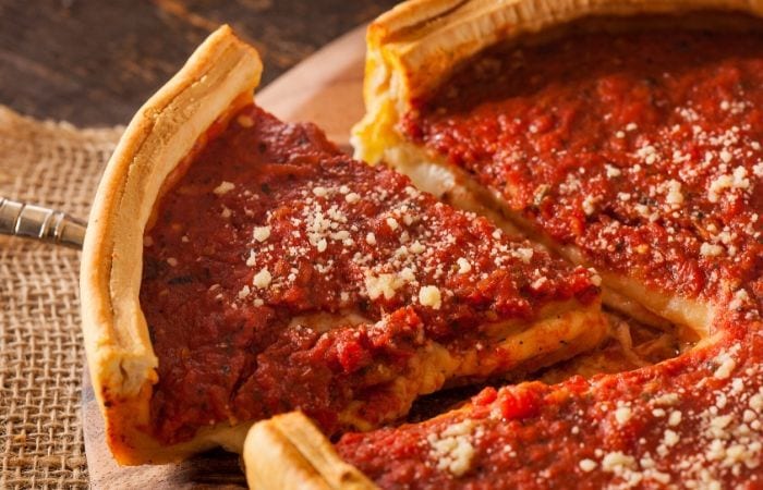 Cutting a slice of Chicago style deep dish pizza