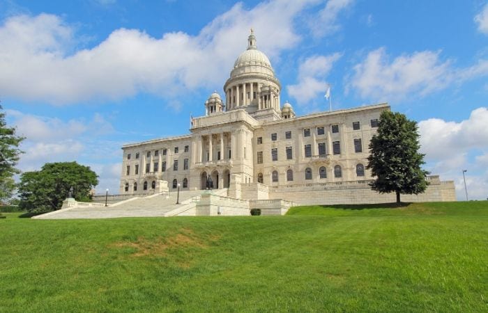 Rhode Island state house with green grass in front and blue sky behind