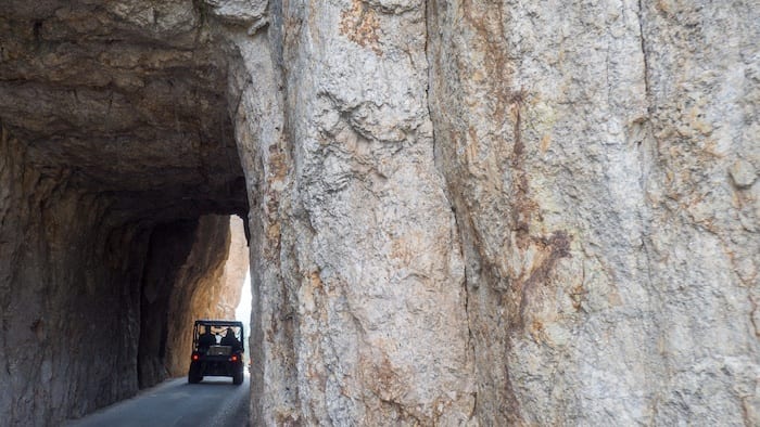 Jeep driving through rock tunnel on Needles Highway
