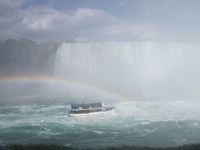 Maid of the Mist boat under rainbow approaching Niagara Falls