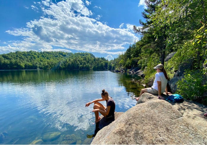 Girl and mom sitting on the rocks by Copperas Pond