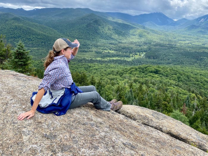 Female hiker sitting and holding hat on top of Mt Von Hovenberg