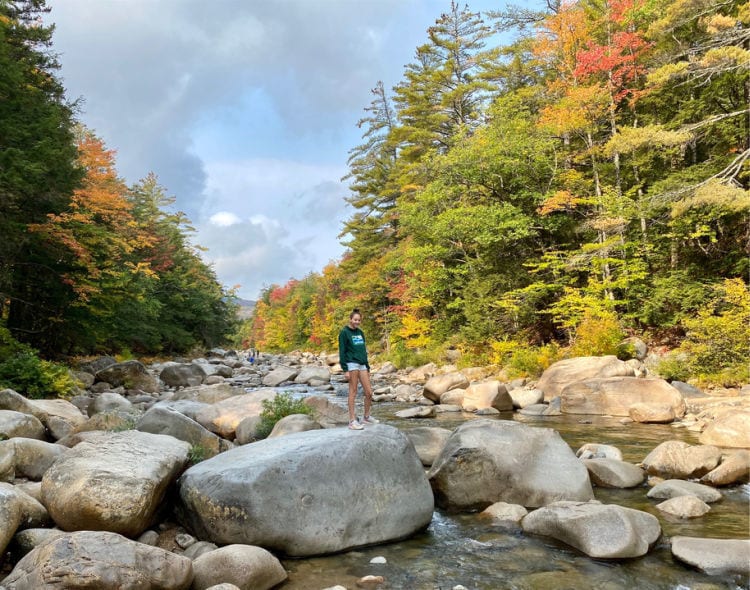 Girl climbing on rocks on the Swift River