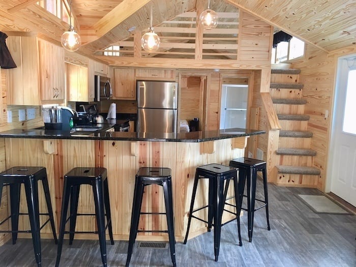 Normandy Farms deluxe cabin kitchen counter with stools and stairs to loft.