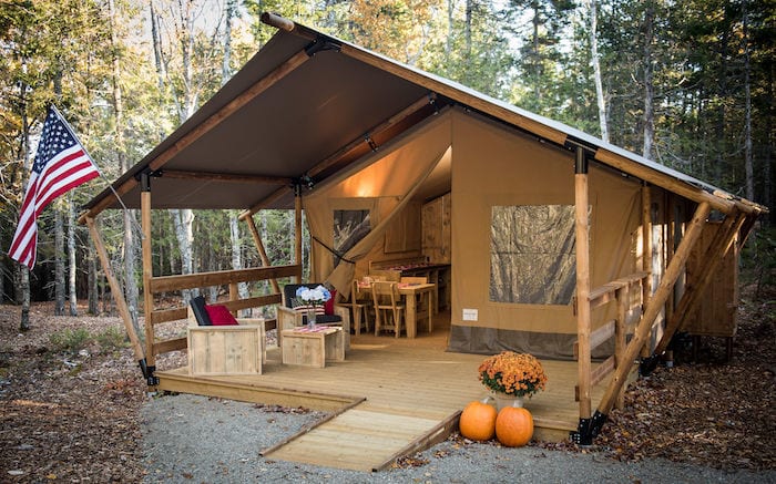 Luxury glamping tent at Woods of Eden with American flag and pumpkins in front