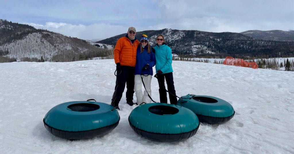 Family with snow tubes in the snow