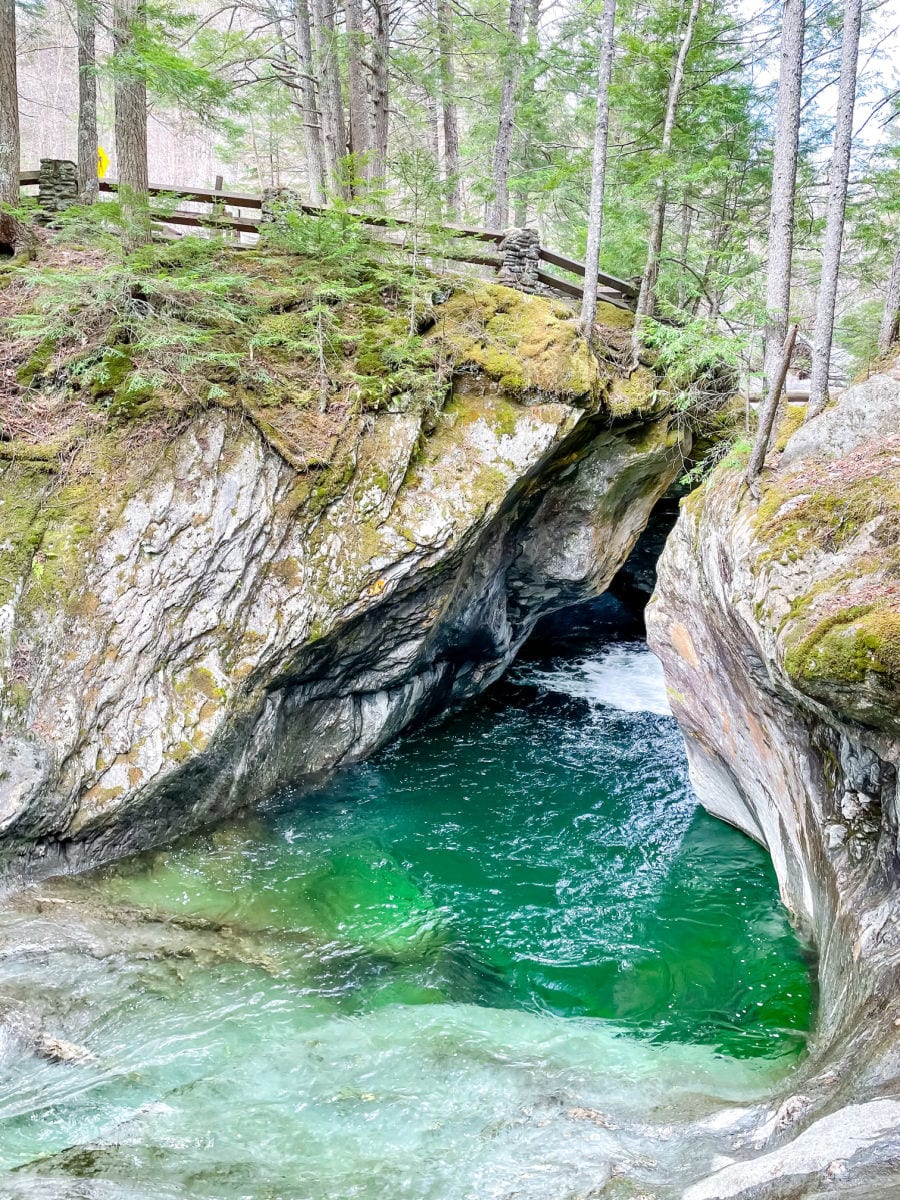 Water cutting through rocks with a fence above at Texas Falls Recreation area in Vermont