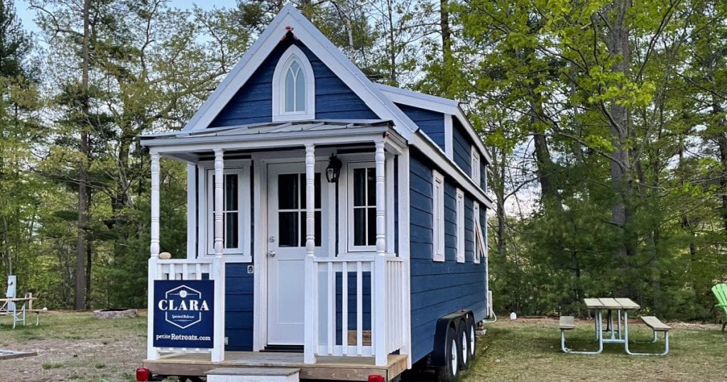 Blue and white Clara style tiny house at Tuxbury Pond