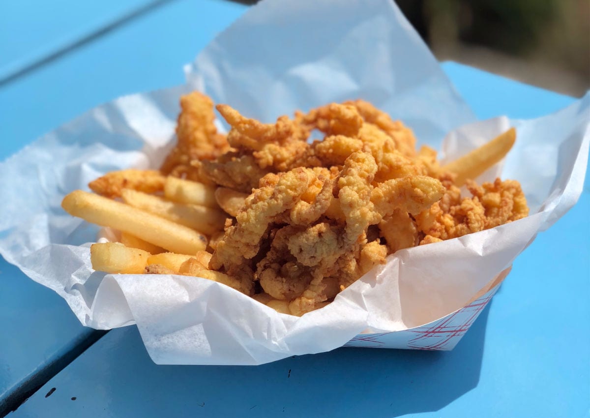 Fried clams and fries on a blue table from Bob's Clam Shack