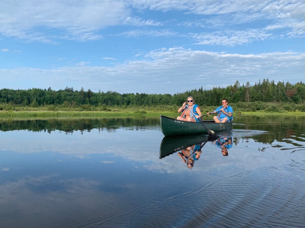 couple in a canoe on Roach Pond in Maine