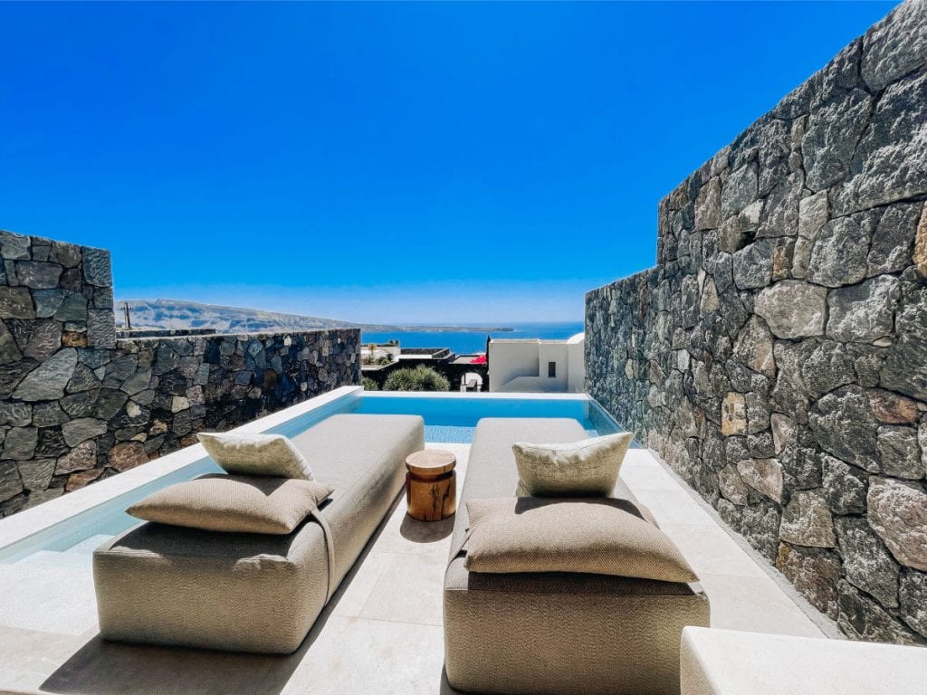 Private plunge pool with two lounges overlooking water view