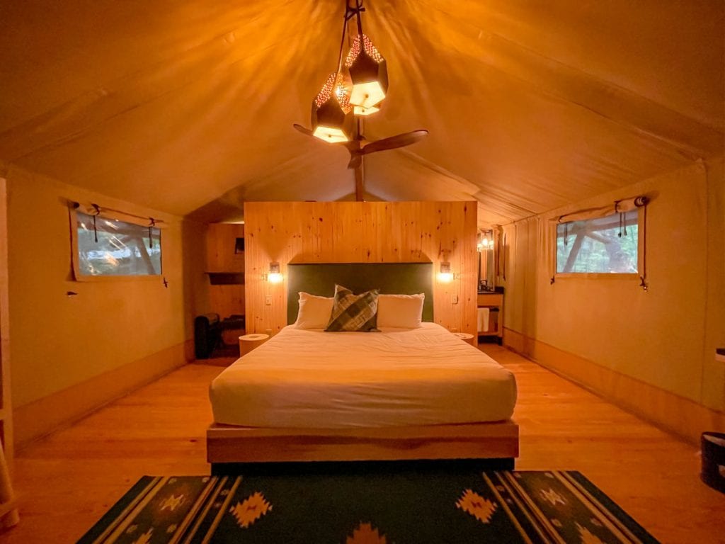 Inside the Bayberry tent at Terramor in the evening with the ceiling fan light on looking at the bed