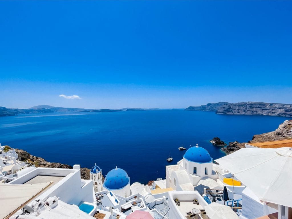 Caldera view with two blue domed churches in Oia Santorini