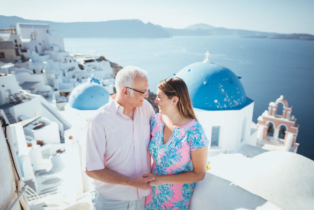 Couple in Oia Santorini with blue dome church in background