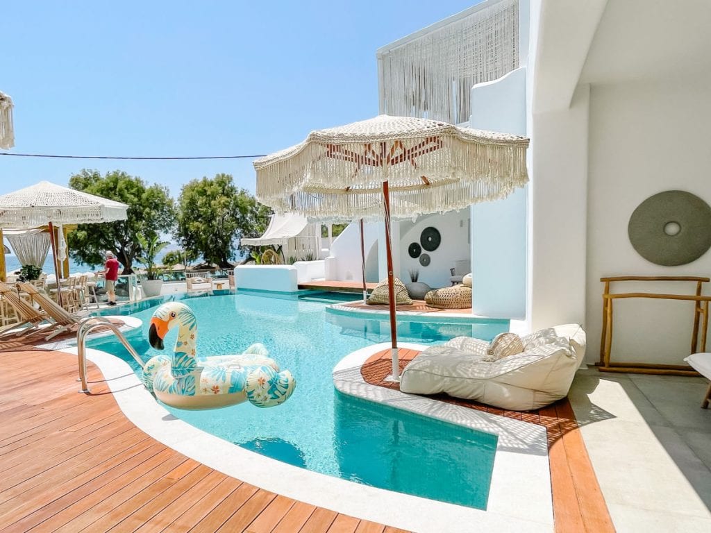 Hotel pool with a flamingo float and lounge beds