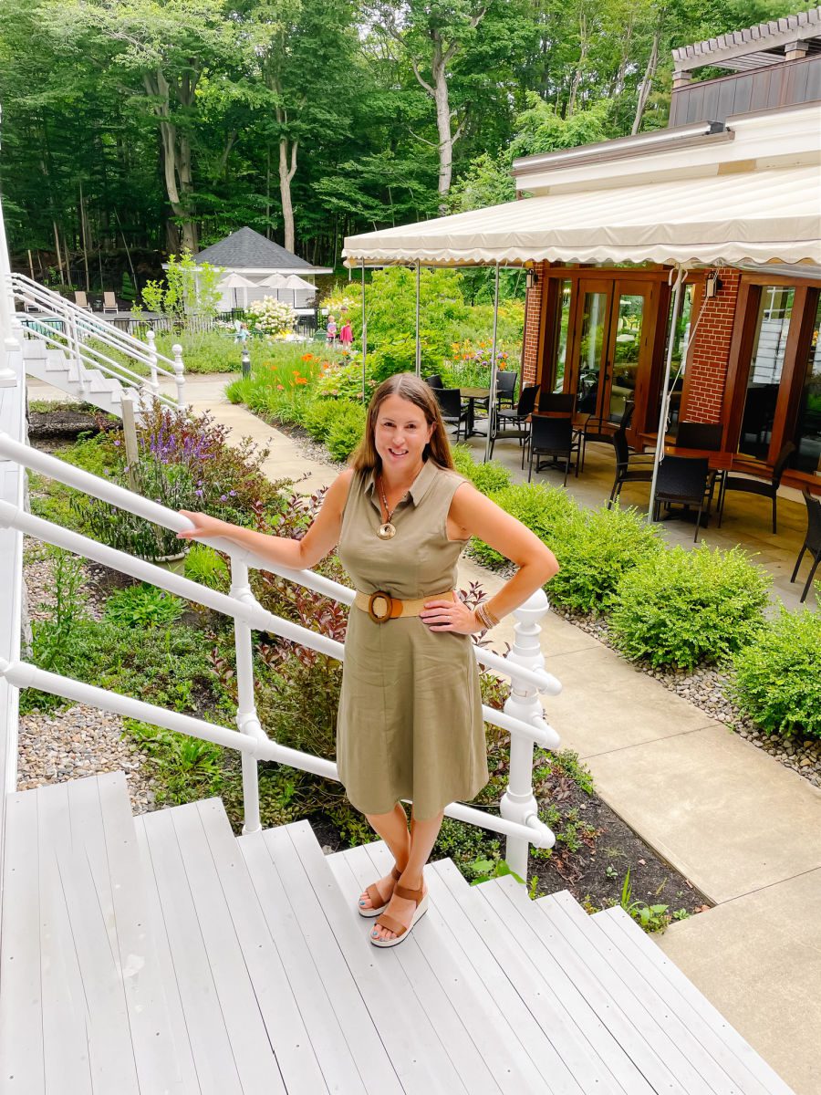 Woman in brown dress standing on stairs in courtyard at the Inn at Diamond Cove