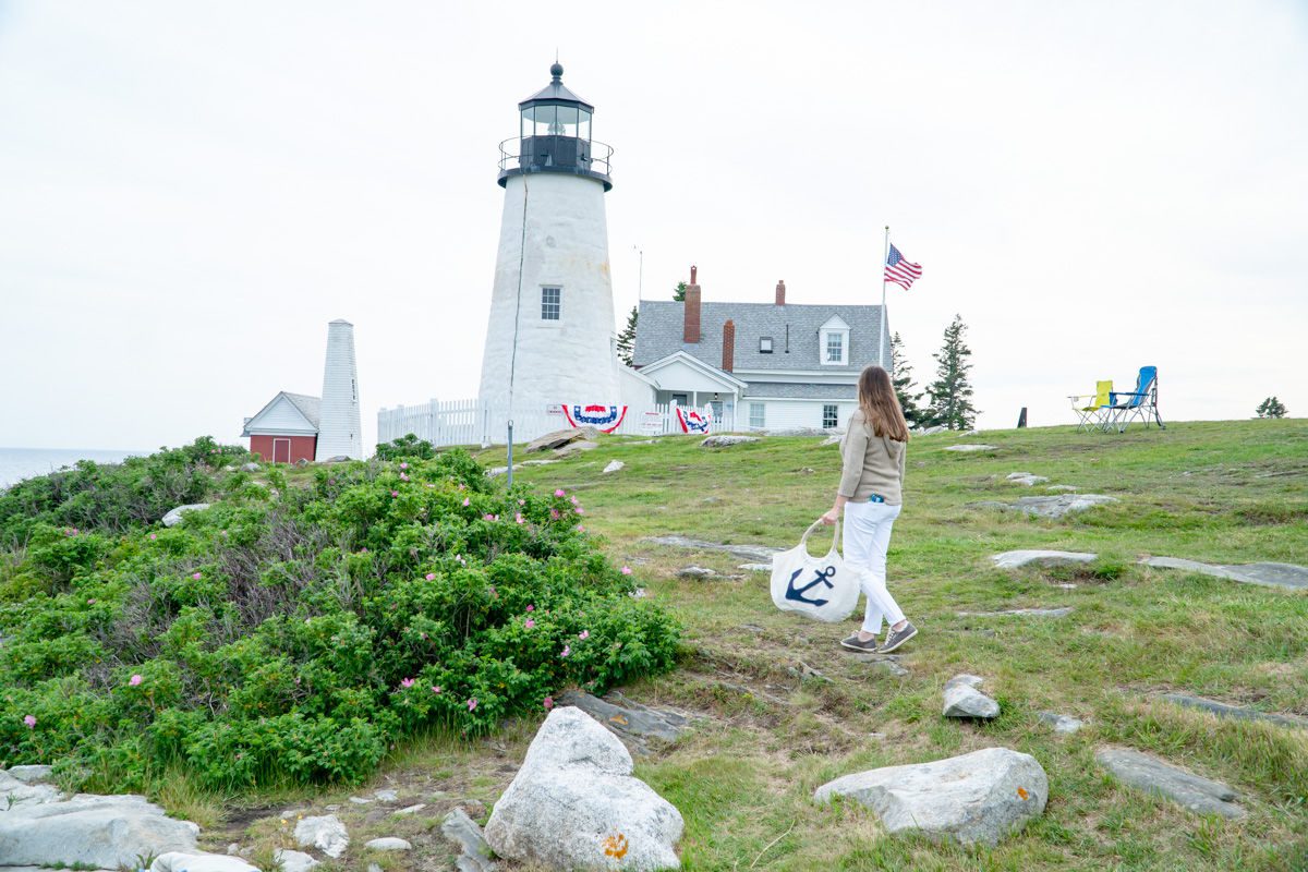 Woman holding anchor Maine Sea Bag in front of Pemaquid Point Lighthouse