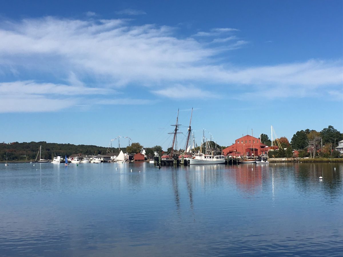 Mystic harbor with boats on water and fall color on trees