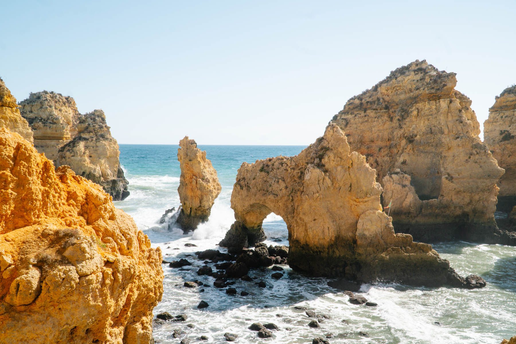 waves crashing around rock formations off the coast of Lagos, Portugal