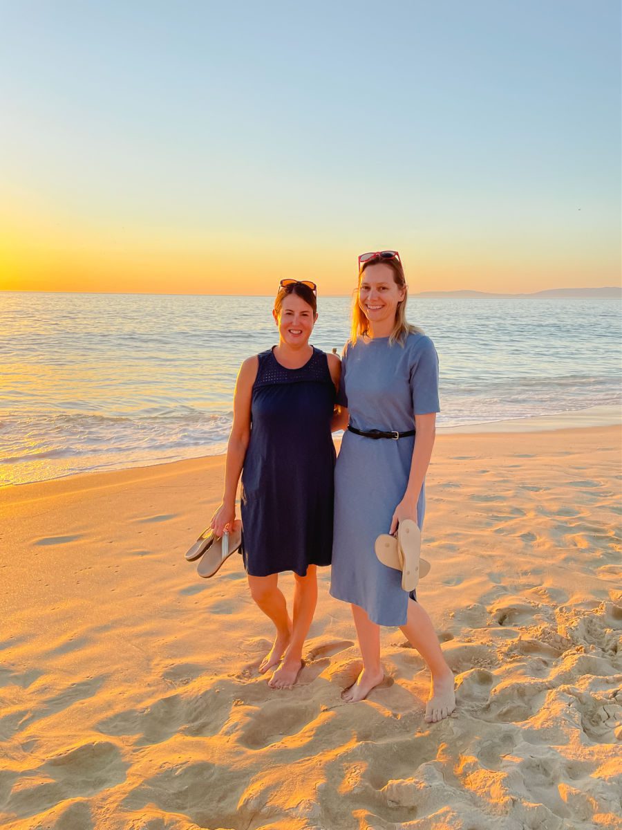 2 women on the beach at sunset in blue dresses