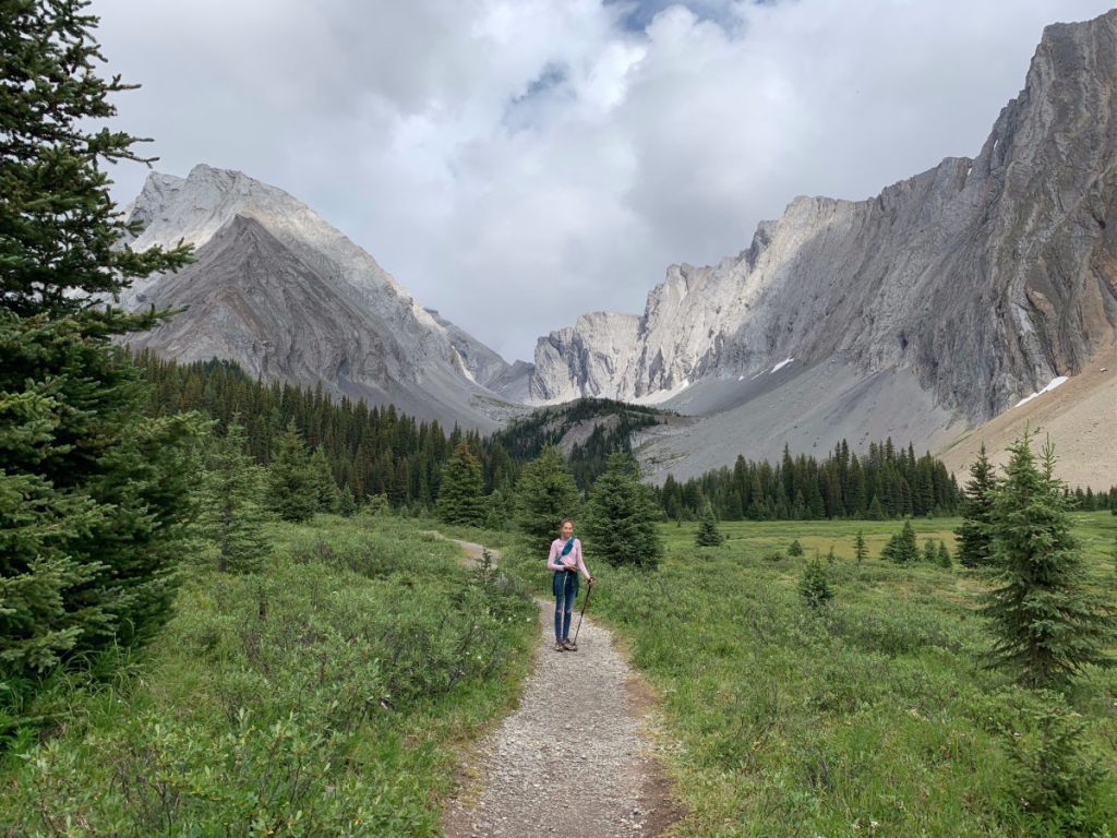 Girl on hiking path with mountains in the background