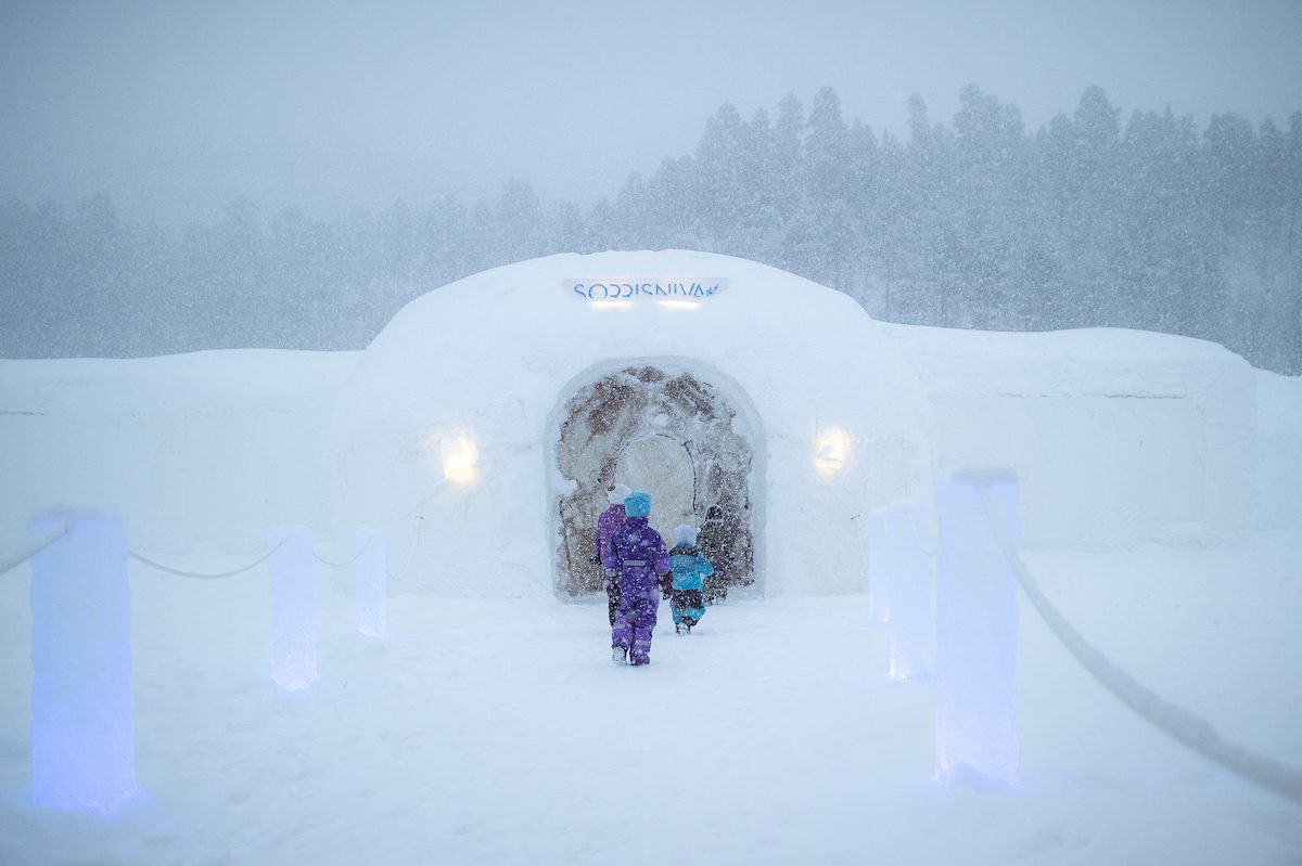 Kids entering a ice igloo in the snow