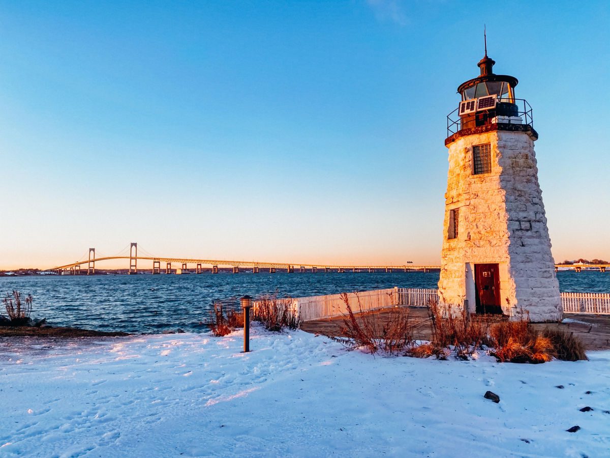 Goat Island lighthouse in the snow with Pell Bridge in the background