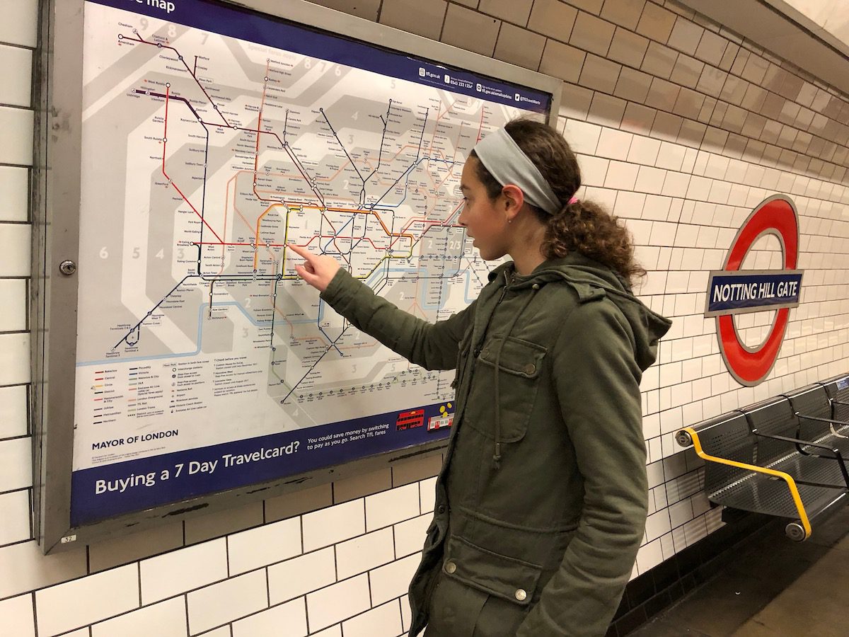 Girl pointing to an underground map at Notting Hill Gate station