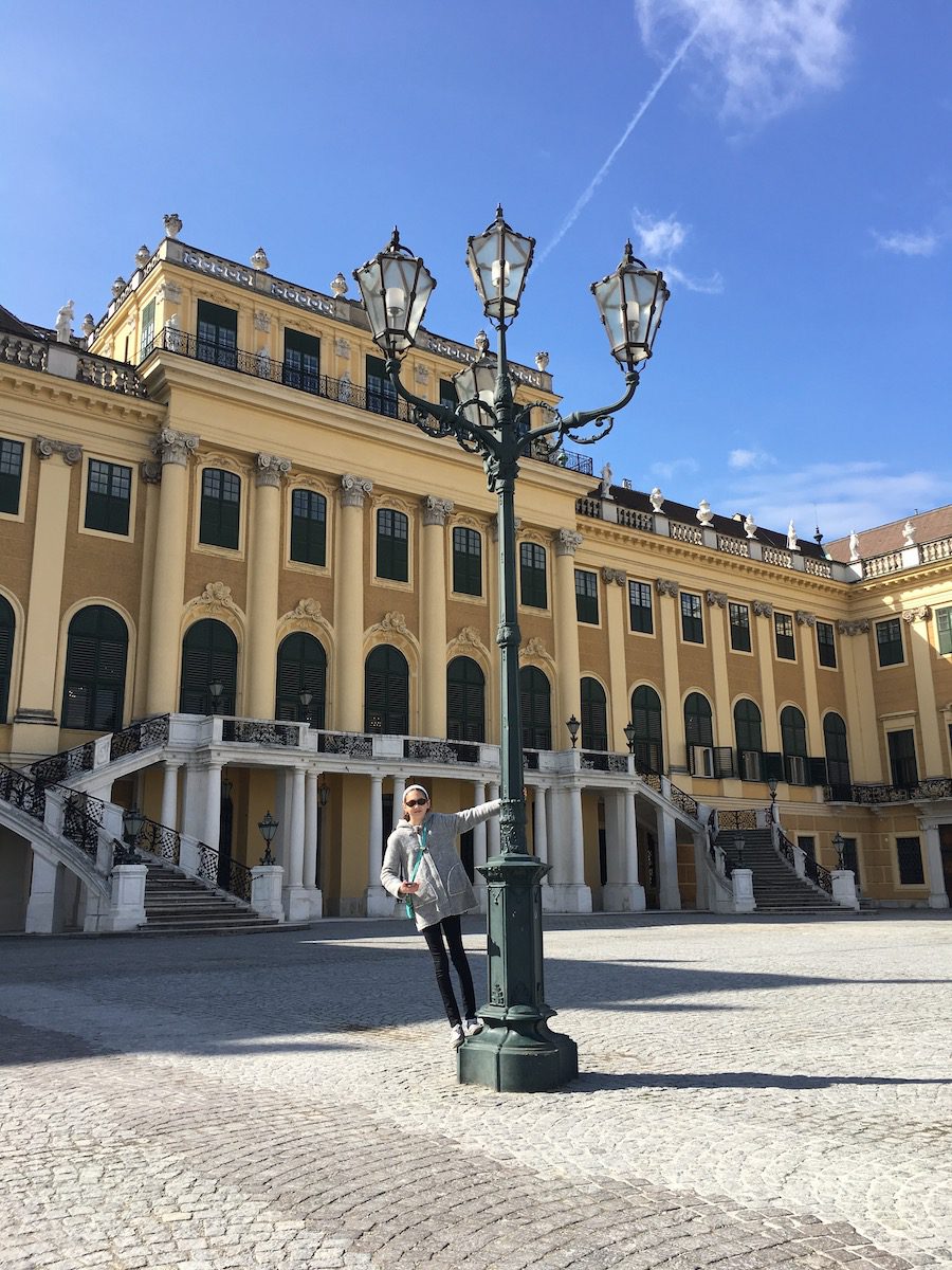 Girl climbing lamppost outside of the Schonnbrunn palace