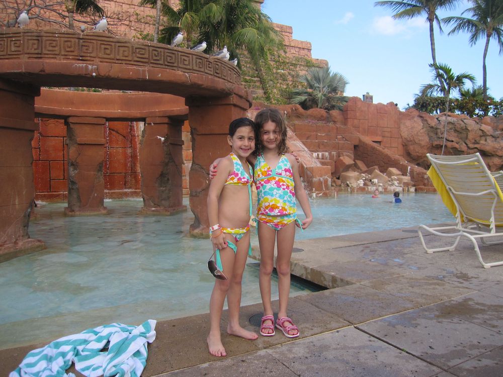 2 girls standing in front of pool at the waterpark at the Atlantis Bahamas