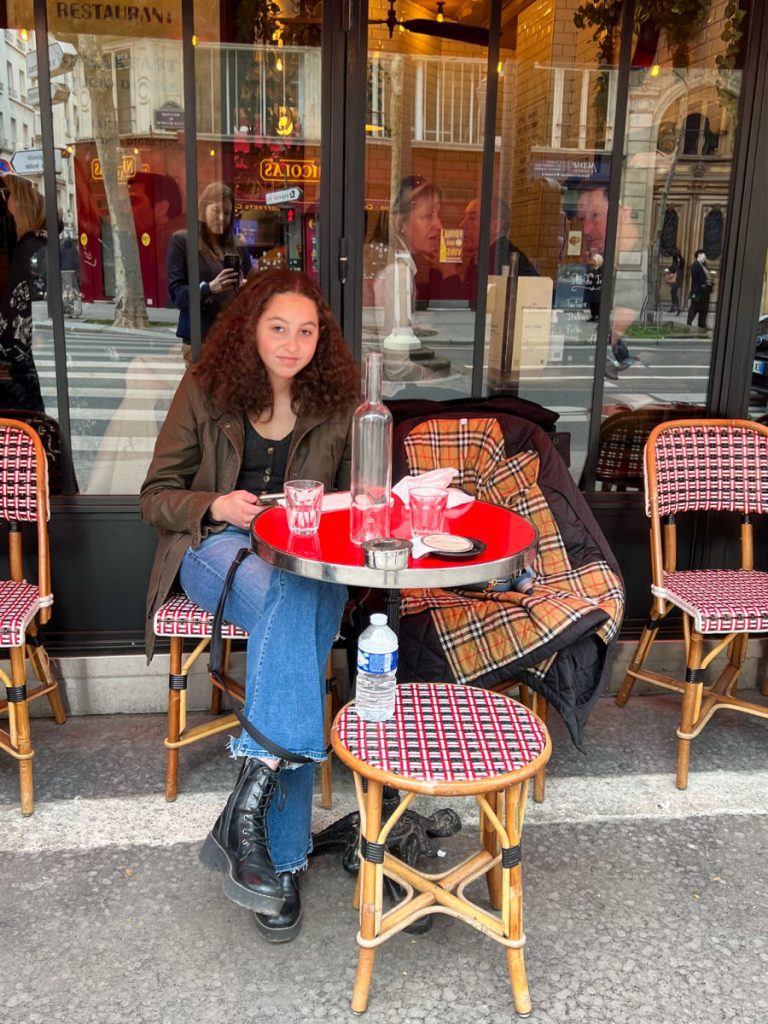 Girl eating at outdoor table at Le Recrutement cafe