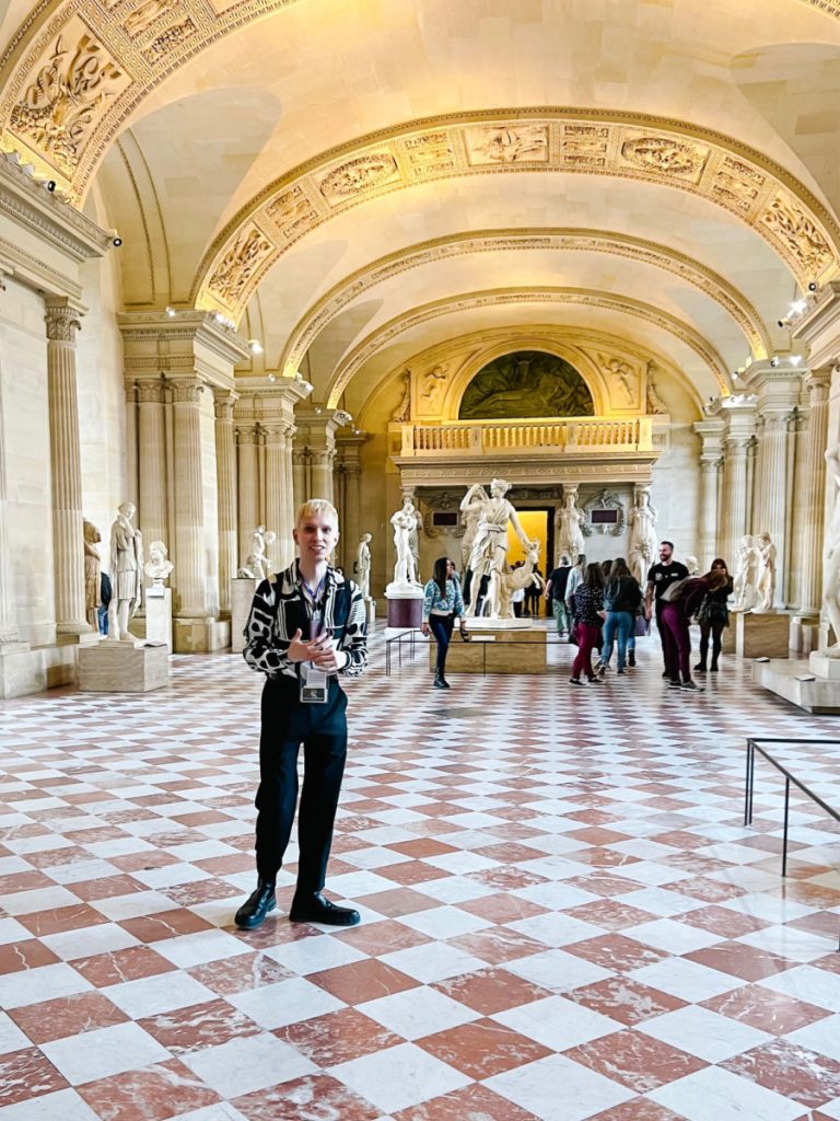 Greek statues and guide in the Louvre