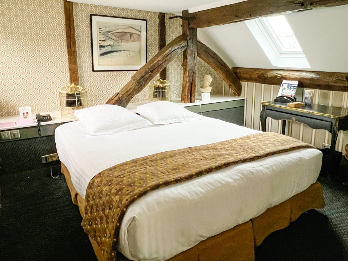 Bed with wood beams on ceiling in the suite with terrace