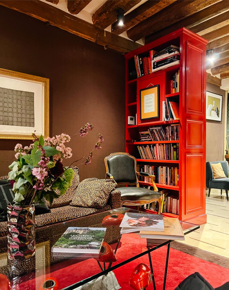 Red bookshelves and couch in lobby of hotel