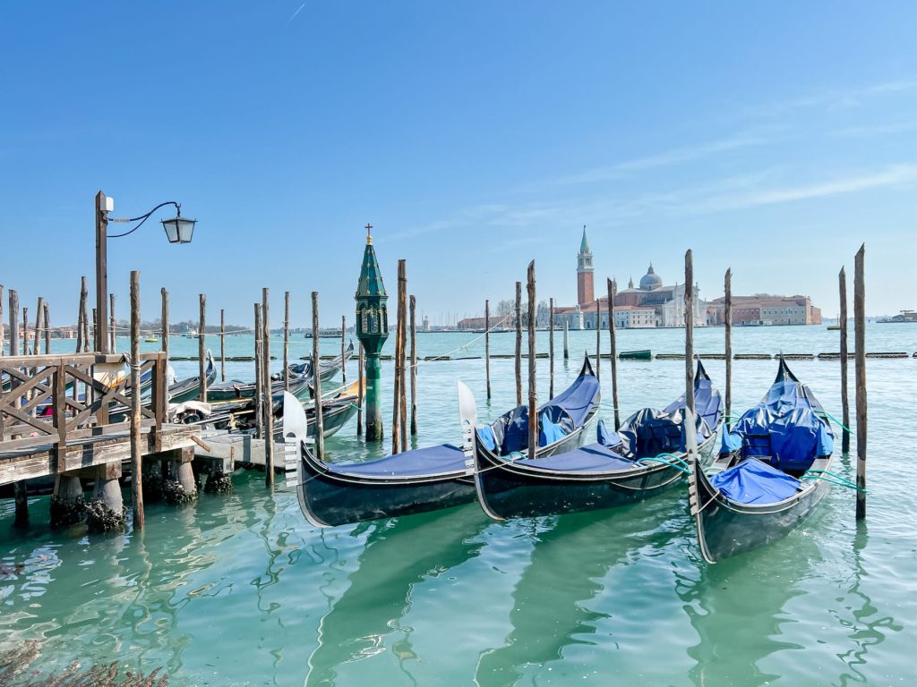 3 gondolas parked in the lagoon in venice