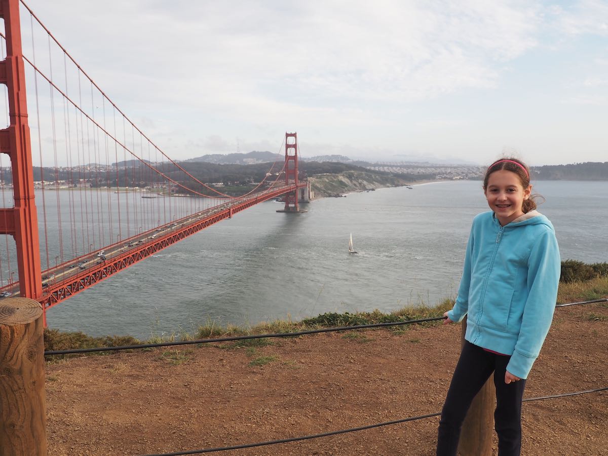 Girl on hill overlooking Golden Gate Bridge in San Francisco