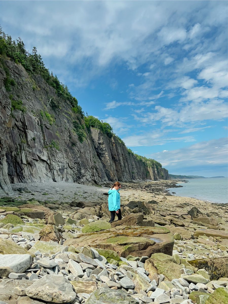Woman walking on the rocks near the cliff at Cape Enrage