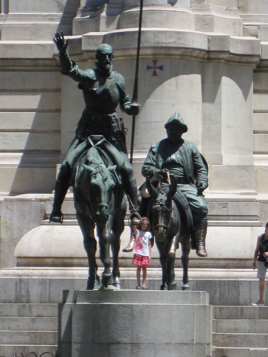 Girls standing next to Don Quixote statue in Plaza de Espana in Madrid