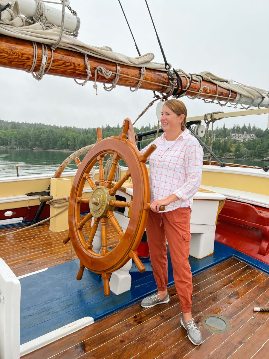 Woman standing at captain's wheel on the Schooner Heritage