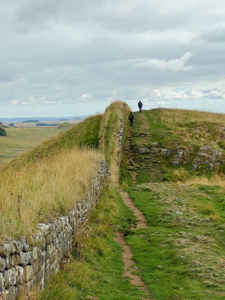People walking up a hill on Hadrian's Wall path