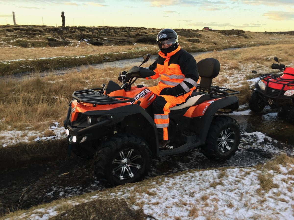 man on ATV in Iceland in orange jumpsuit