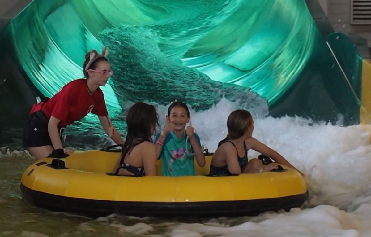Girls in tube at bottom of water slide