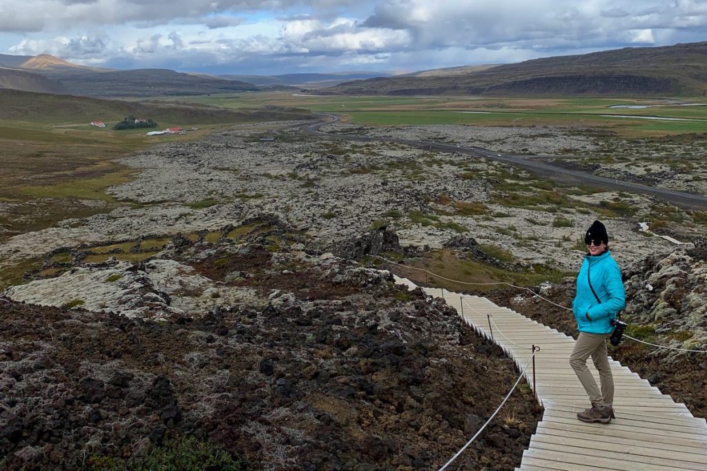 Woman in blue jacket on steps into a crater in Iceland