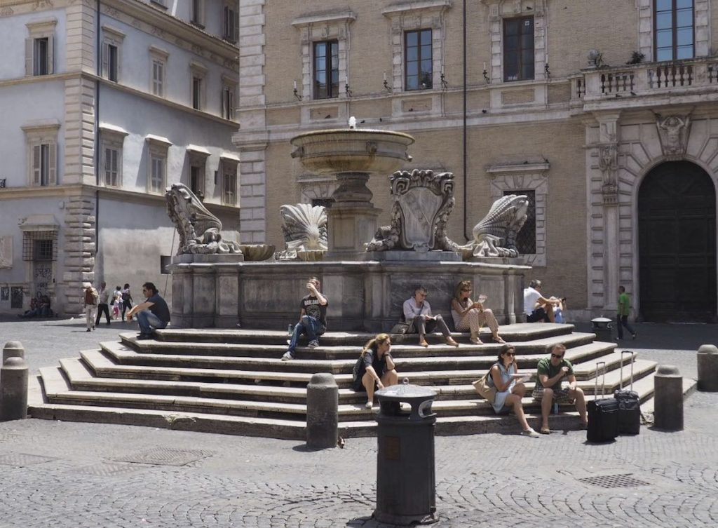 Fountain with people sitting near in in Trastevere