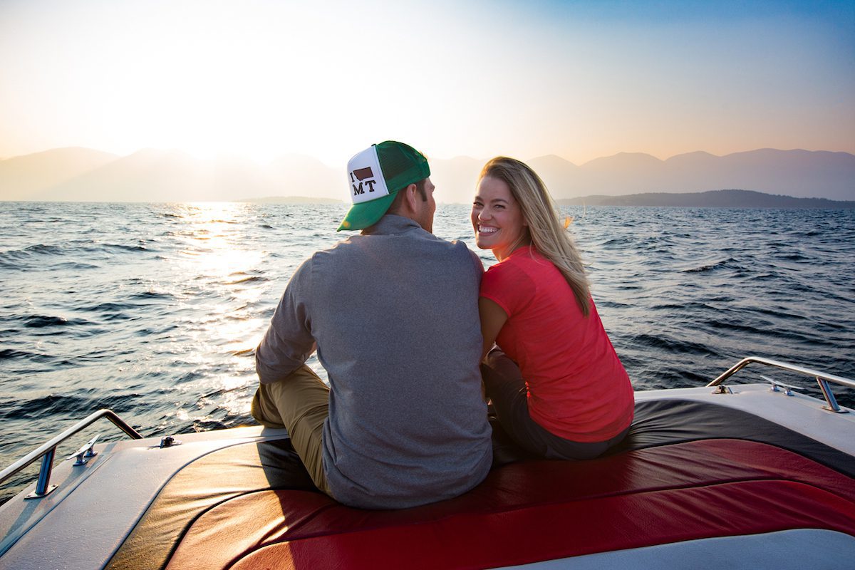 Couple sitting on the back of the boat on Flathead Lake